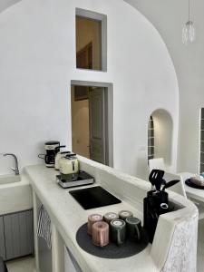 a kitchen with a counter with a stove top oven at Aidos Villa Santorini in Megalokhori