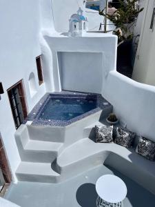 a plunge pool in the middle of a white building at Aidos Villa Santorini in Megalokhori