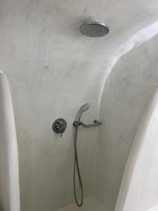 a shower in a bathroom with a shower head at Aidos Villa Santorini in Megalokhori