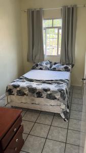 uma cama em um quarto com janela em Recanto do Martins em Florianópolis mais 15 fotografias