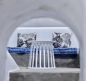a white bench with pillows on a wall at Aidos Villa Santorini in Megalokhori