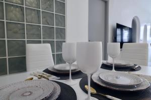 a table with two wine glasses and plates on it at Aidos Villa Santorini in Megalokhori