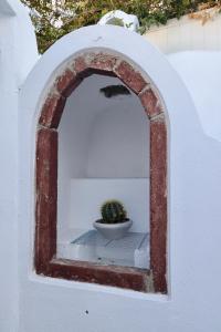 a small plant in a bowl in an archway at Aidos Villa Santorini in Megalokhori