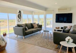 a living room with two couches and a tv at Bayview Hideaway in Point Lonsdale