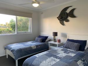 a bedroom with two beds and a fish on the wall at Bayview Hideaway in Point Lonsdale