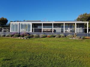 a house with a lawn in front of it at Bayview Hideaway in Point Lonsdale
