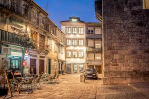 a city street with tables and chairs and a car at Cathedral Design Apartments in Porto