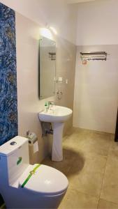 a bathroom with a white sink and a toilet at Nirvan in Varca