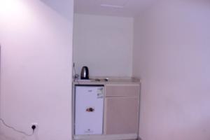 Altamyoiz Sirved Apartments في جدة: ثلاجة صغيرة في زاوية الغرفة