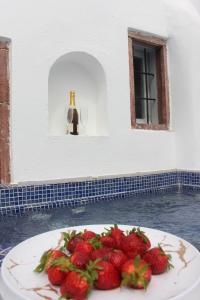 a plate of strawberries on a table with a window at Aidos Villa Santorini in Megalokhori