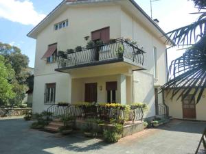 Una casa blanca con balcón y flores. en B&B Morena, en Cormòns