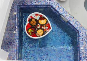 a bowl of food on top of a swimming pool at Aidos Villa Santorini in Megalokhori