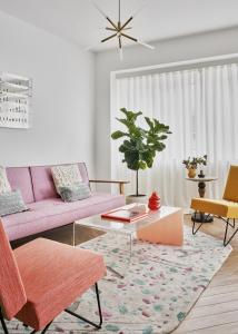 a living room with a pink couch and a table at Halcyon Days Luxembourg in Luxembourg