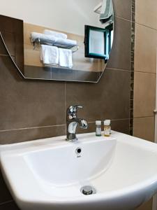 a white sink in a bathroom with a mirror at Hotel Agnanti Unique Hospitality in Kastoria