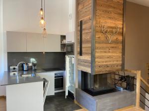 a kitchen with a fireplace in the middle of it at Le Lodge Chasse Montagne in Les Gets