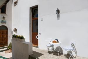 a table and chairs in front of a white building at Appartamento luminoso e romantico ANyMA in Massa Lubrense