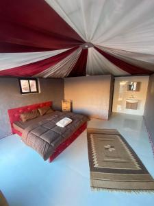 a room with a bed and a large tent at Wadi Rum Moon Light Camp in Wadi Rum