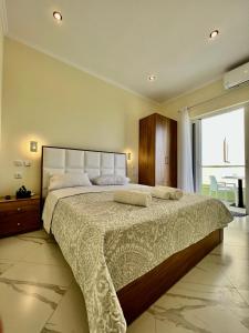 a bedroom with a large bed with two towels on it at Oscar’s Apartments Drymades in Dhërmi