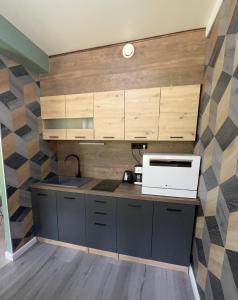 een keuken met houten kasten en een magnetron bij Forest apartments in Kouvola