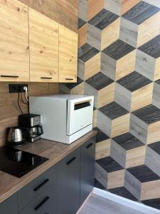 a kitchen with a white microwave and a wooden wall at Forest apartments in Kouvola