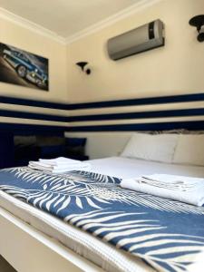 Una cama con sábanas azules y blancas y toallas. en enjoy hotel, en Fethiye