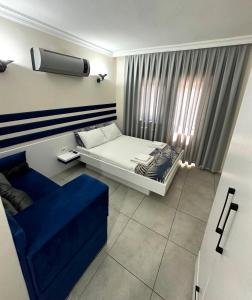 ein Schlafzimmer mit einem Bett und einem blauen Sofa in der Unterkunft enjoy hotel in Fethiye