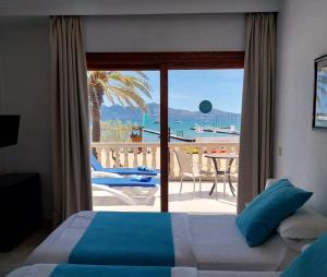 a bedroom with a bed and a view of the ocean at Apartamentos Torre Playa in Port de Pollensa