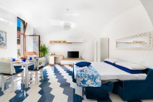 1 dormitorio con 1 cama y comedor en Appartamento luminoso e romantico ANyMA, en Massa Lubrense