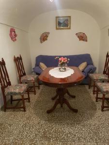 un soggiorno con tavolo, sedie e divano di Cueva Maite a Cortes de Baza