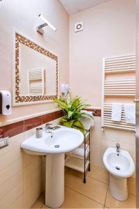 a bathroom with a sink and a mirror and a toilet at B&B Studio83 Pompei in Pompei