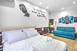 una camera con un letto bianco e un divano blu di B&B Studio83 Pompei a Pompei