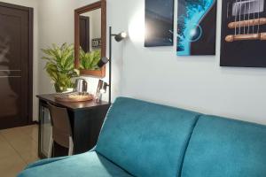 a blue couch sitting in a room with a desk at B&B Studio83 Pompei in Pompei