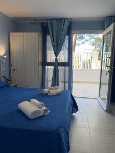 a bedroom with two towels on a blue bed at HOTEL MERCURIO SUL MARE - Fish restaurant and private beach in Capo Vaticano