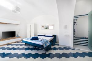 1 dormitorio con cama azul y suelo azul y blanco en Appartamento luminoso e romantico ANyMA, en Massa Lubrense