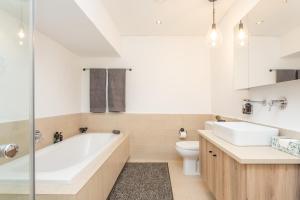 ein Badezimmer mit einer Badewanne, einem WC und einem Waschbecken in der Unterkunft Edgy On Bree in Kapstadt