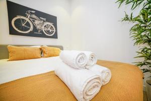 a pile of towels sitting on top of a bed at Alvito Charm Apartments in Lisbon