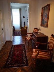 a living room with a table and chairs and a rug at Weisz Castle style Apartment - With Free Private Parking,Wifi in Carei