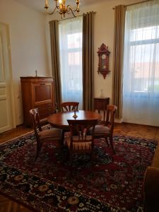 a dining room with a table and chairs on a rug at Weisz Castle style Apartment - With Free Private Parking,Wifi in Carei