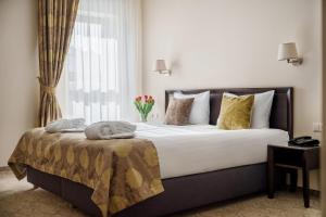 Un dormitorio con una cama grande y una ventana en Euterpe Hotel, en Klaipėda