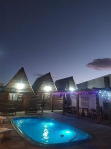 una casa con piscina por la noche en Cabanas Rústicas Refúgio da Marola en São Lourenço do Sul