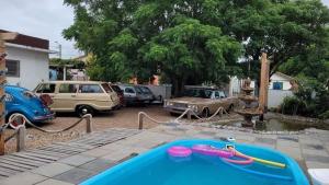 una piscina con coches estacionados en un patio en Cabanas Rústicas Refúgio da Marola en São Lourenço do Sul