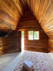 Habitación grande con 1 cama en una cabaña de madera. en Cabanas Rústicas Refúgio da Marola, en São Lourenço do Sul