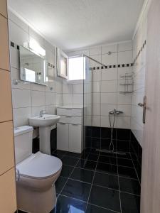 a bathroom with a toilet and a sink at Ethos Apartment in Nea Peramos