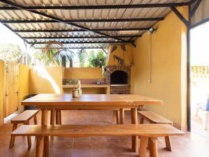 una mesa y bancos en un patio con chimenea en EDEN RENTALS North Paradise "House B", en Santa Catalina