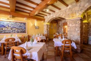 a restaurant with tables and chairs and a painting on the wall at Djudja i Mate - Rooms and local restaurant in Vid
