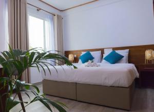 a bedroom with a large bed with blue pillows at Nihaali Maldives in Kudarikilu