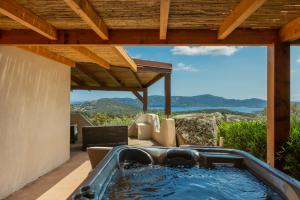 un bain à remous sur la terrasse d'une maison dans l'établissement SWIM LODGE HOTEL Piscine privée ou Jacuzzi privé, à Porto-Vecchio