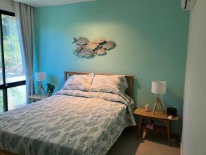 1 dormitorio con cama y pared azul en Kluai Mai Luxury Pool Villa, Panorama Resort, en Hua Hin