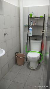 a bathroom with a toilet with a green hose at Rumah Lunas in Lunas