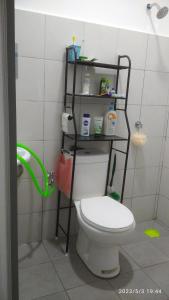 a bathroom with a toilet with a shelf above it at Rumah Lunas in Lunas